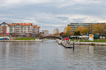 Obraz premium Paisagem serena vista do Cais da Fonte Nova, Aveiro, com seus canais tranquilos, barcos coloridos e arquitetura típica, refletindo a beleza única e o charme pitoresco da cidade portuguesa