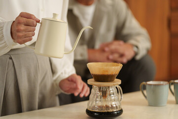 夜にコーヒーを淹れる夫婦..