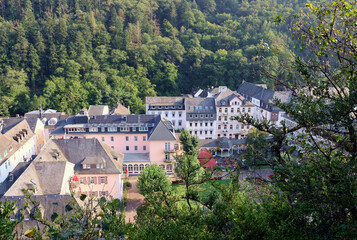 Obraz premium Der Kurort Bad Bertrich mit Blick auf den Kurgarten im Landkreis Cochem-Zell zwischen bewaldeten Hügeln. Aussicht vom Wanderweg Wasserfall-Erlebnisroute.