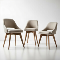 Fototapeta premium Upholstered dining chairs with slim, tapered wooden legs and muted fabric seats, standing against a white background.