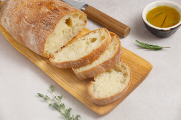 Fresh sliced ciabatta with olive oil on an ancient cutting boarda