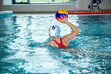 На фотографии изображены дети которые тренируются водным поло в большом и светлом бассейне. ворота