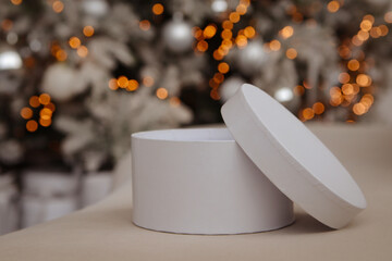White gift box. Against the background of New Year's bokeh. New Year. Close-up. Copyspace