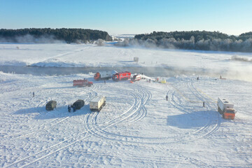 Early morning on the winter river fog and snowing many cars nearby training rescuers