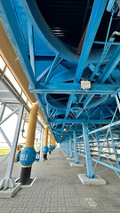 На фотографии современный вентилятор синего цвета с желтым цветом детали на нем  для охлаждения оборудование на открытом воздухе .