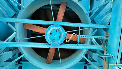 На фотографии современный вентилятор синего цвета с желтым цветом детали на нем  для охлаждения оборудование