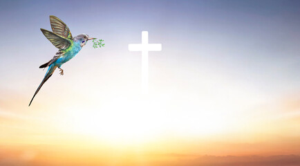 Christian Cross and bird with a sunrise sky background
