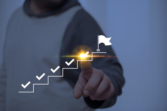 Person pointing at a glowing step on a staircase with checkmarks leading to a flag, symbolizing goal achievement, progress tracking, and success in personal or professional milestones.