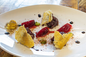 DEER TARTARE – a light and fresh dish. The meat rediscovers the flavors of the woods in the mayonnaise flavored with porcini mushroom powder and the confit plums enhance the tartare with their sweetne