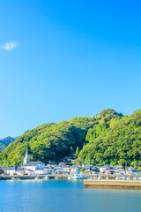 Fototapeta premium 初秋のカトリック﨑津教会と街並み 熊本県天草市 Catholic Sakitsu Church and cityscape in early autumn. Kumamoto Pref, Amakusa City.