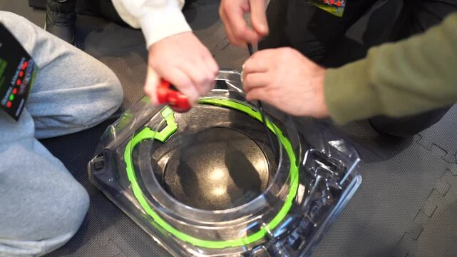 Popular and trendy boy beyblade spinning toy match and battle. Green elements of battle arena for beyblades in slow motion