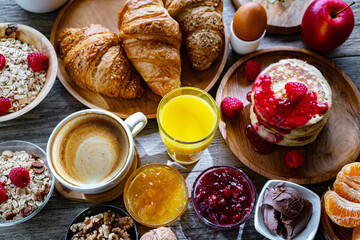 Breakfast served with coffee, orange juice, pancakes, croissant
