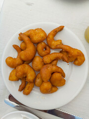 A plate of golden, crispy battered shrimp served fresh and ready to enjoy. Ideal for food menus, seafood promotions, and travel visuals.