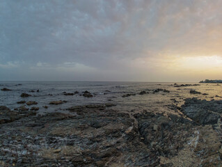 Rocky Beach in Málaga at Sunset with Calm Waves and Soft Sky