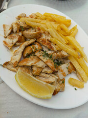 Grilled Chicken and French Fries Served on a Sunny Terrace in Málaga