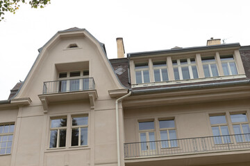 This charming multistory building features large windows for natural light, a lovely balcony for outdoor enjoyment, and a unique rooftop design that adds character to the property