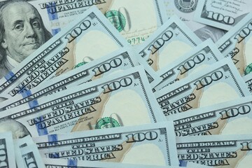 Many hundred dollar bills new banknotes in big pile under the natural light