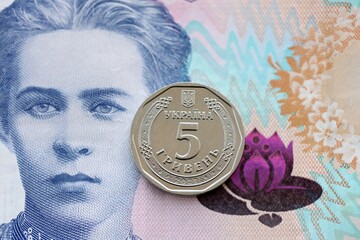 Ukrainian silver coin lies on two hundred hryvnia bill. Financial and business concept. Modern...