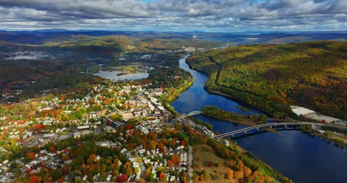 Panorama of Vermont, New England near the river. Dramatic cloudscape throwing shadows on the scenery. Aerial perspective.