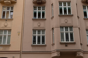 Fototapeta premium A closeup of a residential buildings facade highlights many windows and air conditioning units, creating a striking urban aesthetic that enhances the citys overall character and allure
