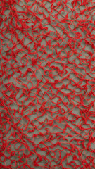 Textured red fabric showcasing intricate woven pattern with artistic flair