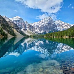 a breathtaking view of a serene mountain lake with crystal-clear waters. Include snow-capped peaks reflected in the lake, surrounded by lush green forests and a clear, tranquil sky