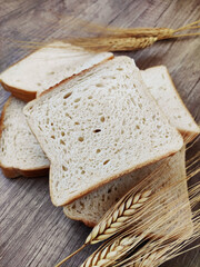 Square pieces of white toast bread and ears of dry wheat	