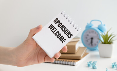 Businessman holding a card with text Sponsors Welcome