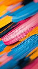 Vibrant abstract strokes of pink, yellow, blue, and black paint creating an artistic texture on a canvas