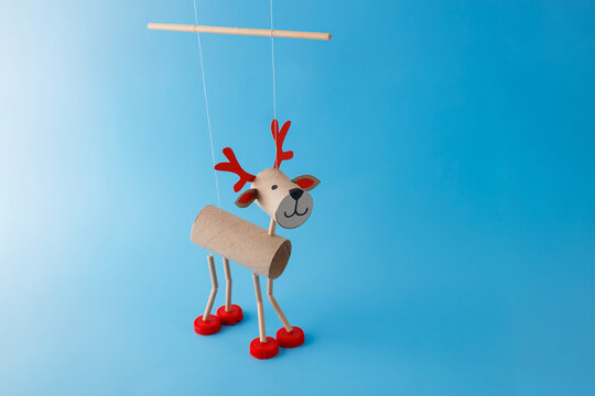 a paper craft reindeer with red antlers and a cute face. art supplies, decorative items, cut out, holiday theme