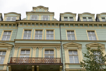 The stunning facade of a beautifully preserved historic building showcases elegantly designed balconies, intricate architectural details, and large, inviting windows that capture the citys charm