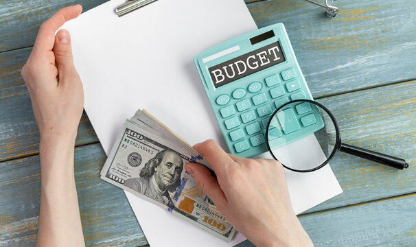 Close up of woman planning home budget and using calculator.