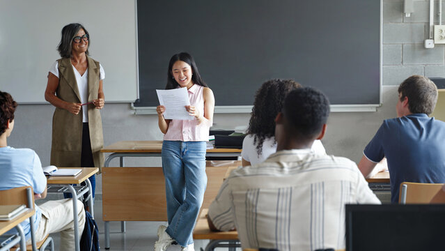 Asian girl college student reading project presentation to classmates and teacher at High School