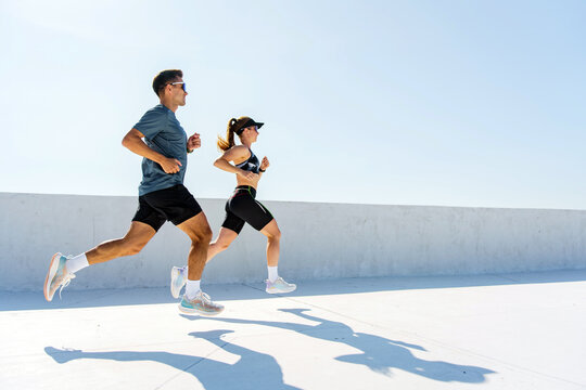 Couple Running Together on a Sunny Day, Enjoying Outdoor Fitness and Healthy Lifestyle