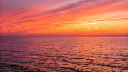 Obraz premium Ocean horizon stretches into vibrant orange and pink hues of sunset, sunsets at sea, color gradation, abstract landscape