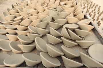 Obraz premium Freshly crafted raw clay pots drying under sunlight, showcasing traditional pottery techniques and natural craftsmanship in a rural settings, whole process to make pottery, selective focus 