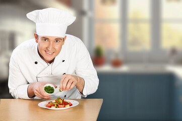 Man chef with plate cooking in kitchen