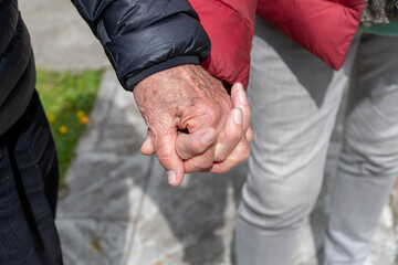 Elderly Hands Intertwined While Walking
