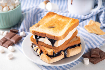S`mores toasted bread sandwiches with a lot of toasted roasted marshmallow, melted chocolate, Christmas winter tasty breakfast or snack idea, copy space