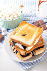 S`mores toasted bread sandwiches with a lot of toasted roasted marshmallow, melted chocolate, Christmas winter tasty breakfast or snack idea, copy space