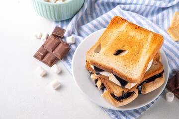 S`mores toasted bread sandwiches with a lot of toasted roasted marshmallow, melted chocolate, Christmas winter tasty breakfast or snack idea, copy space