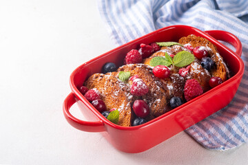 Christmas Morning French Toast Baking, holiday morning french toast casserole, sweet simple dessert with bread, egg and milk mixture and fresh berries