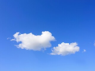 Fototapeta premium Soft white clouds float gently on a brilliant blue sky with fluffy texture and subtle shading, clouds, soft focus, cloud formations