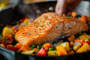 Person preparing a meal with salmon and vegetables
