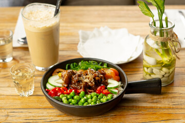 Beef Black Pepper Poke Bowl served on the table with Cappuccino and Iced Tea
