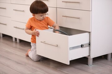 Little boy playing with kitchen appliances indoors. Dangerous situation