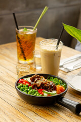 Beef Black Pepper Poke Bowl served on the table with Cappuccino and Iced Tea