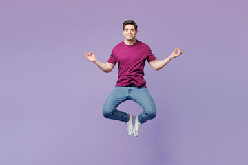 Full body young man he wear violet t-shirt casual clothes jump high hold spreading hands in yoga om aum gesture relax meditate try to calm down isolated on plain pastel light purple background studio.