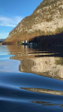 vertical view of lake waters. Fresh air, blue sky along the horizon, mountain skyline, picturesque fishing villages Famous tourist region. Austria