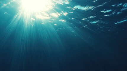 Beneath surface, sunlight filters through water, creating serene rays